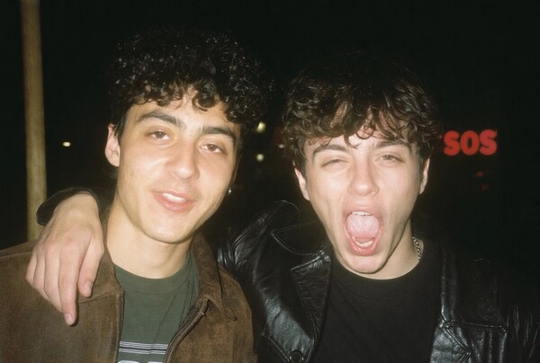 GPT Image 2 example: flash-lit portrait of two friends at night with neon sign in the background