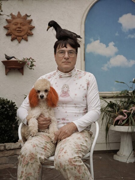 GPT Image 2 example: man in floral matching outfit holding a poodle with dyed ears and a bird on his head