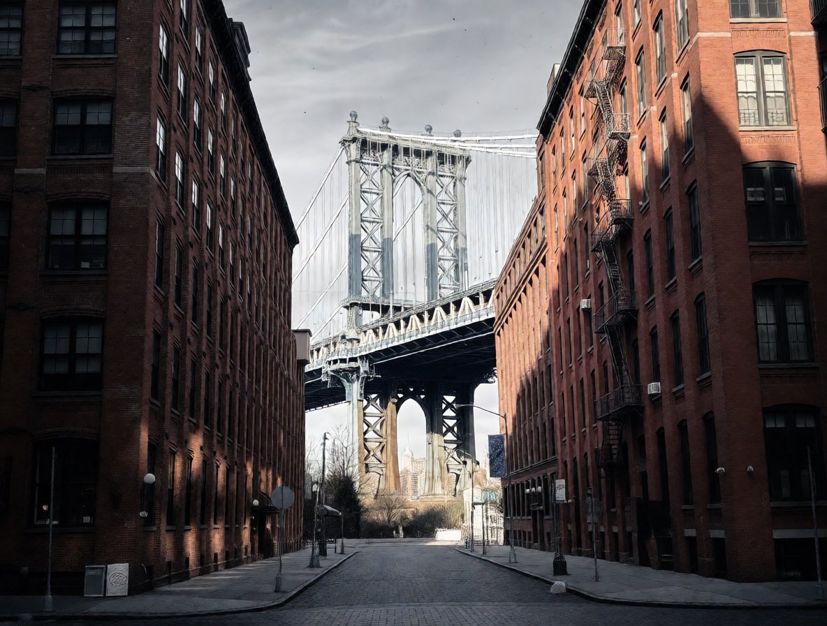 Qwen Edit example: narrow city street lined with brick buildings framing a distant suspension bridge