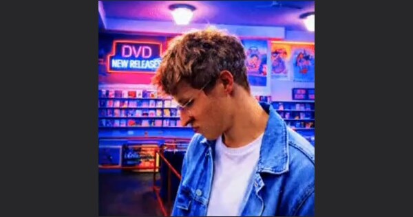 Square photo of a man in a DVD store, before expanding.